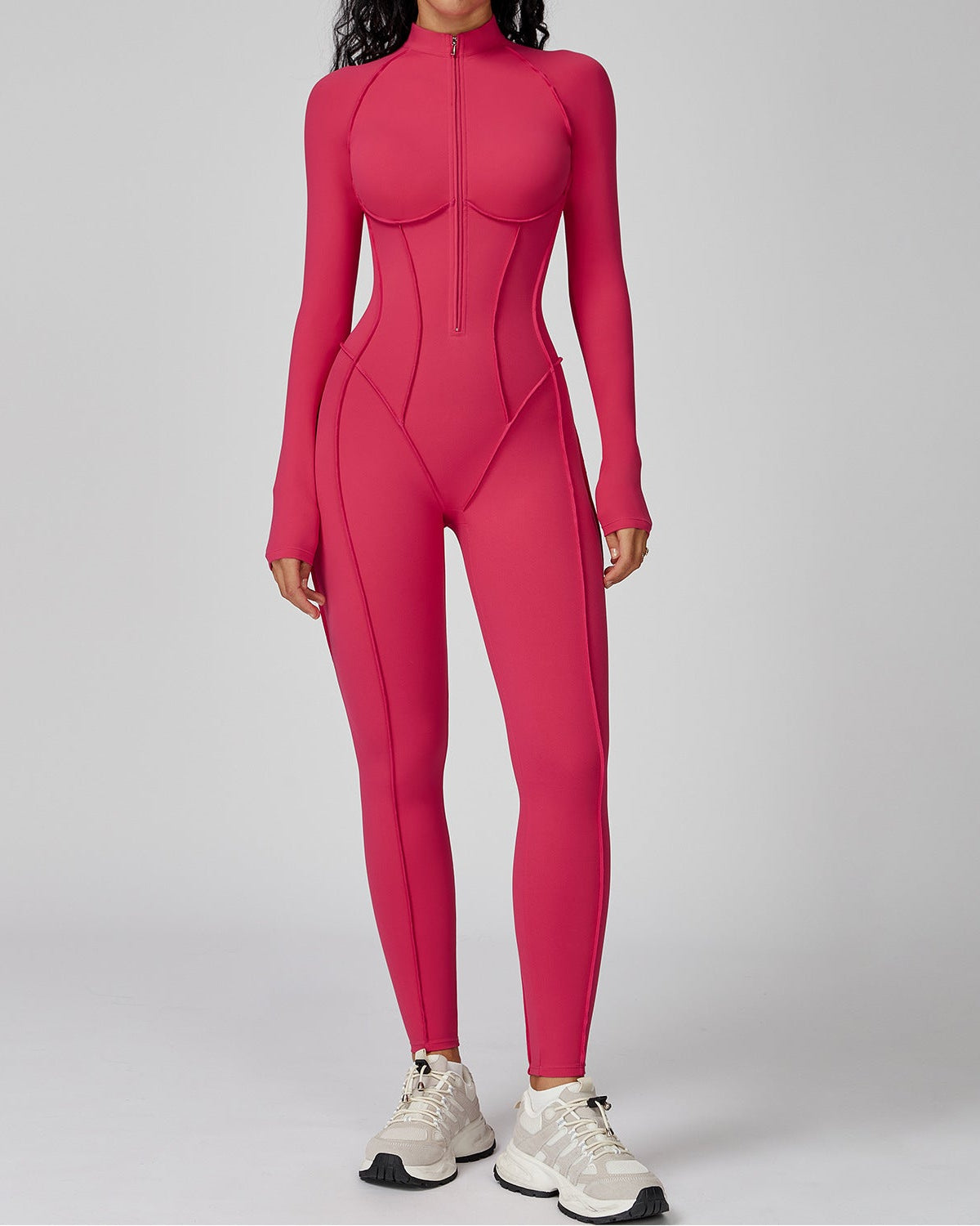 Person wearing a pink bodysuit on a gray background