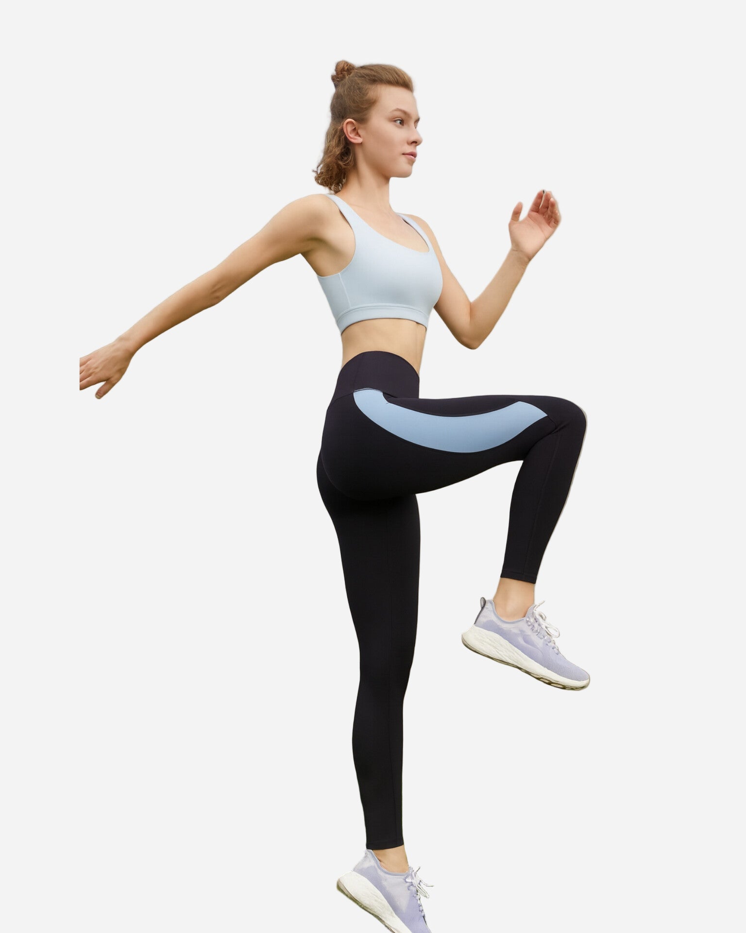 Woman in athletic wear posing outdoors with a clear sky background