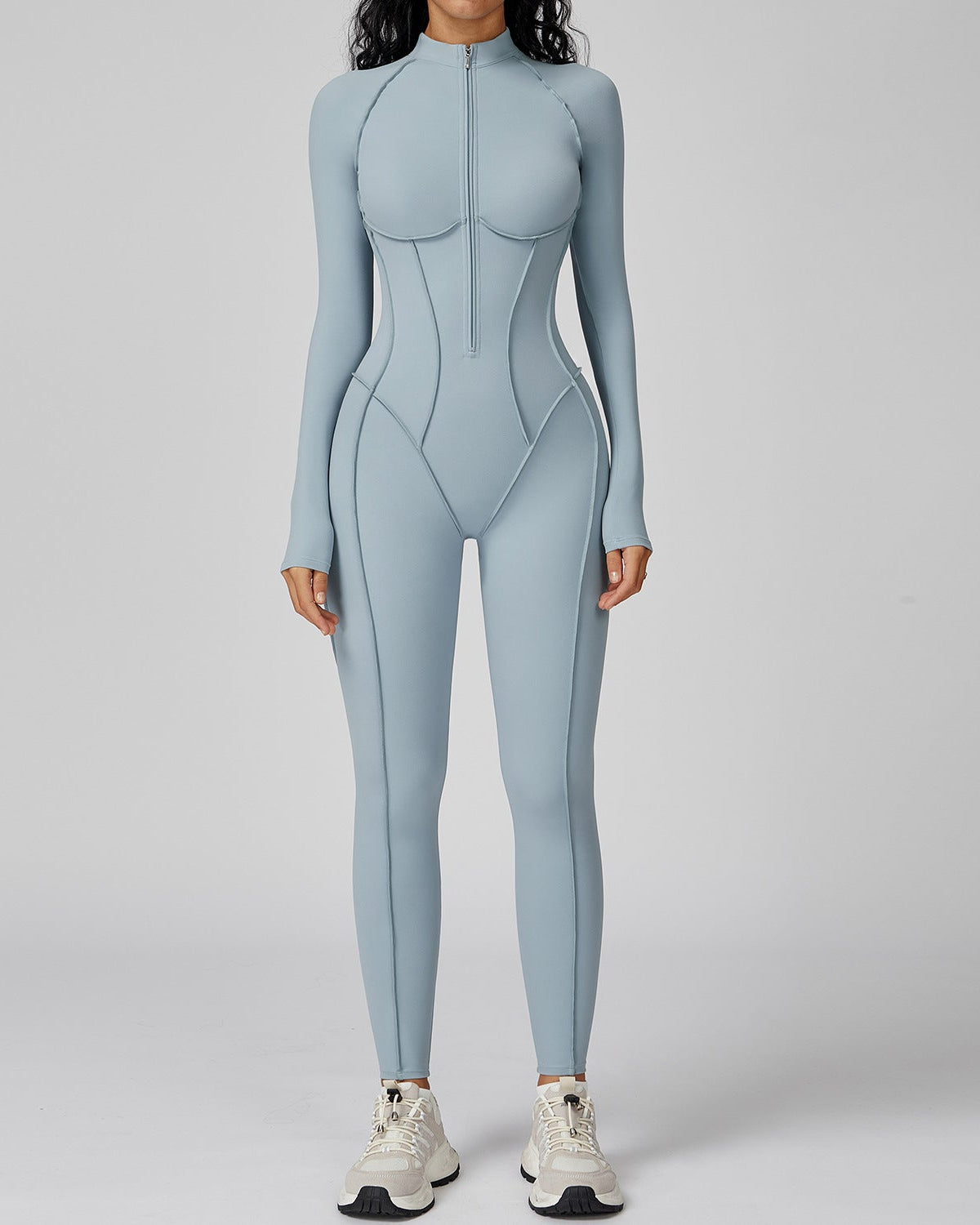 Person wearing a light blue bodysuit on a gray background