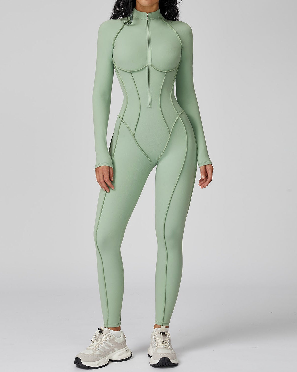 Person wearing a green bodysuit on a plain background